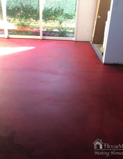 Image shows the subfloor in the living room that has been sealed with the red colored concrete sealer form Mapei.