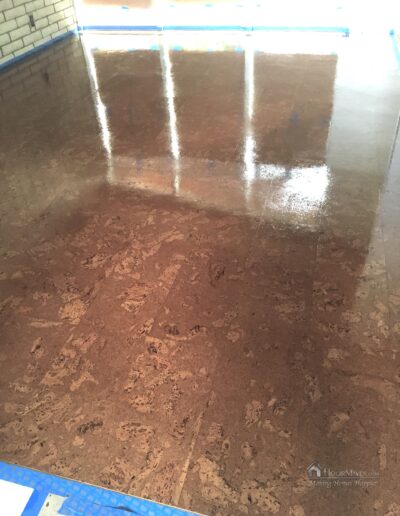 Image shows wet urethane finish applied to the cork floor in the living room.